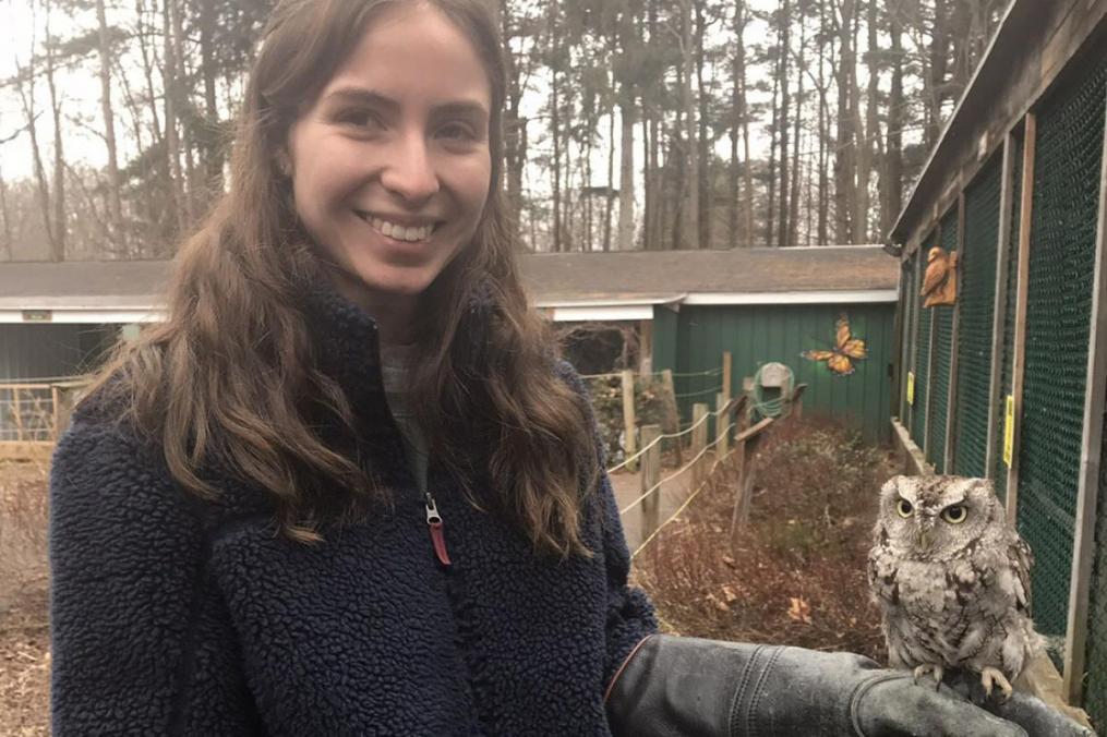 Grace DelRossa posing with a small owl standing on her left hand